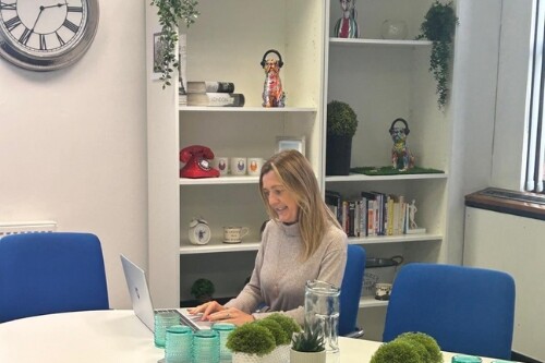 Bien Venue's Managing Director, Kerry Evans, sat at a meeting table looking at her laptop screen